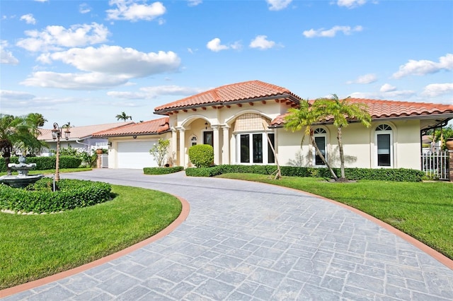 mediterranean / spanish home featuring a garage and a front yard