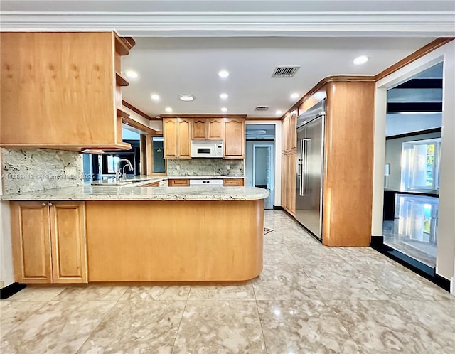 kitchen with stainless steel built in refrigerator, backsplash, crown molding, and kitchen peninsula