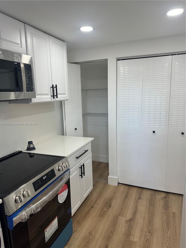 kitchen featuring white cabinets, light hardwood / wood-style floors, and stainless steel appliances