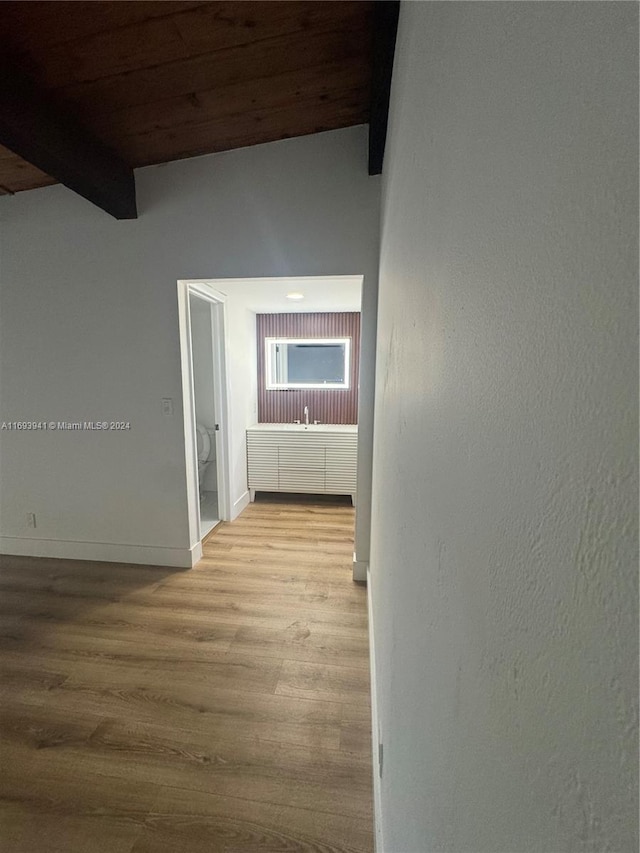 hallway featuring beam ceiling, wood ceiling, and light hardwood / wood-style floors