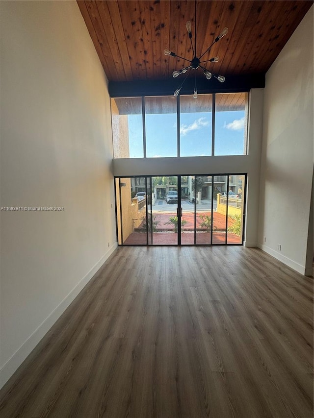 unfurnished living room with a high ceiling, hardwood / wood-style flooring, and wooden ceiling