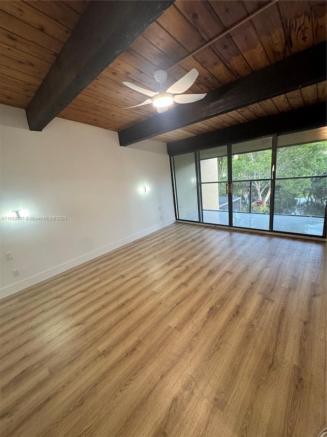 empty room with ceiling fan, beam ceiling, light wood-type flooring, and wooden ceiling