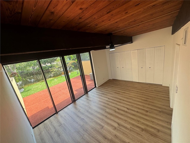 interior space featuring plenty of natural light, a water view, wooden ceiling, and light hardwood / wood-style flooring