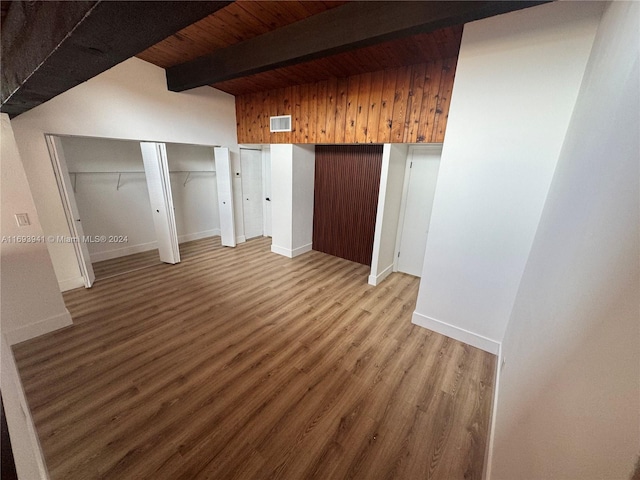 unfurnished bedroom with beamed ceiling, wood-type flooring, and wood ceiling