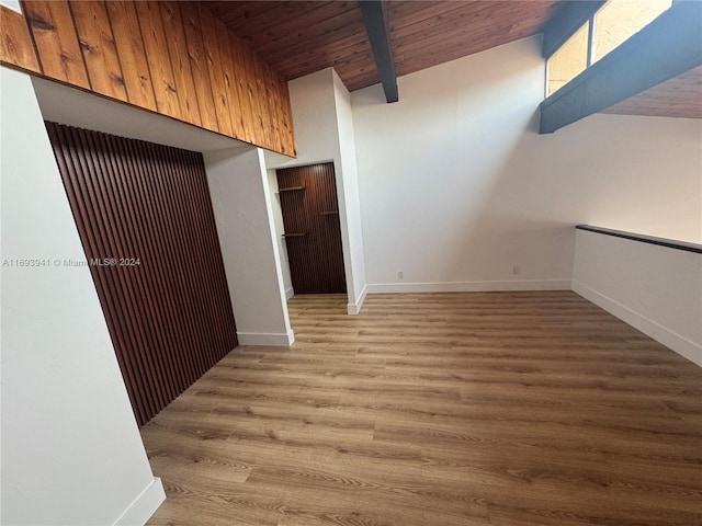 spare room with light wood-type flooring, wooden ceiling, and lofted ceiling