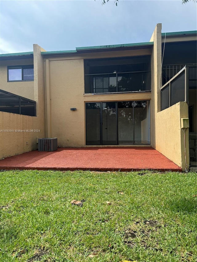 back of property featuring a lawn and a patio