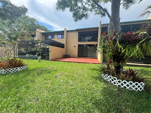 back of property with a lawn, a patio area, and a balcony