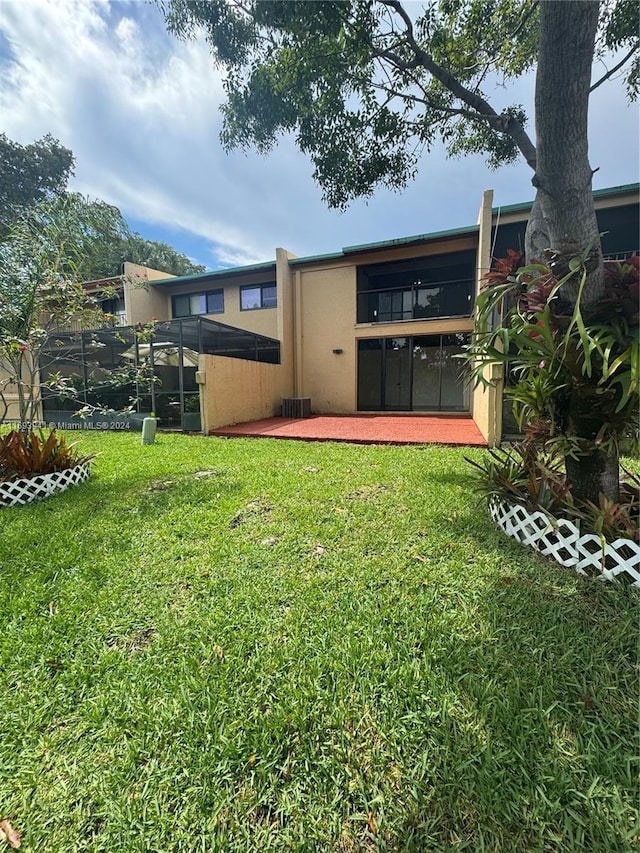 back of house with a lawn and a patio