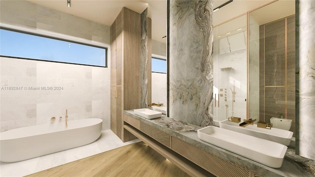 bathroom with hardwood / wood-style floors, vanity, a bathing tub, and tile walls