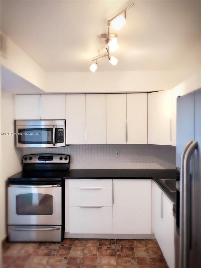 801 Three Islands Blvd Unit 411, Hallandale Beach, FL 33009 - kitchen with appliances with stainless steel finishes, white cabinetry, backsplash, and dark countertops