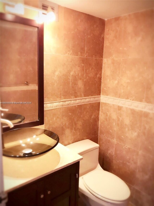801 Three Islands Blvd Unit 411, Hallandale Beach, FL 33009 - bathroom featuring tile walls, vanity, and toilet