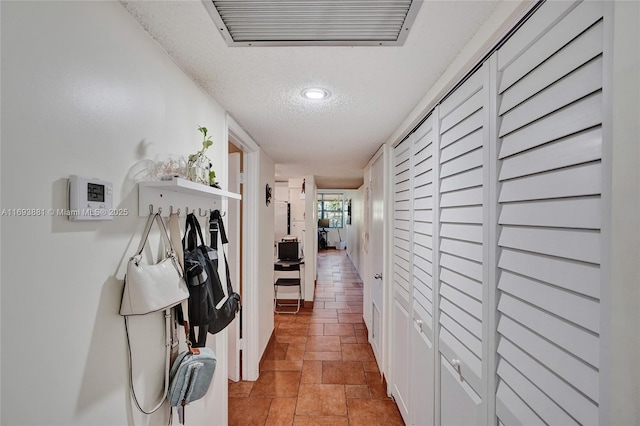 hall with a textured ceiling