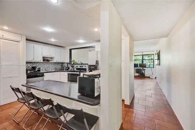 kitchen with white cabinets, stainless steel appliances, and backsplash