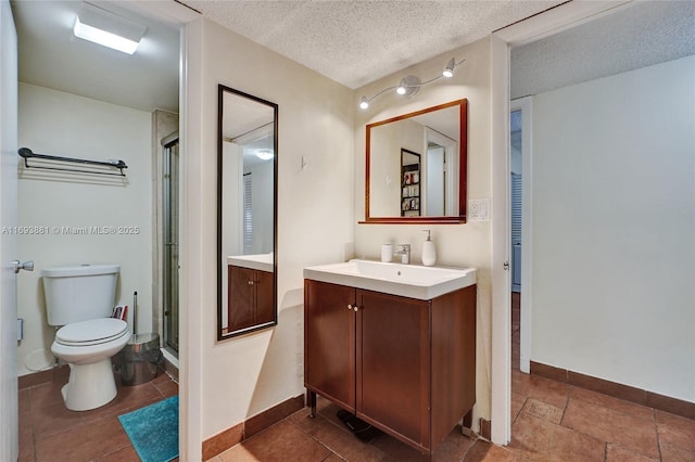 bathroom featuring toilet, a shower with door, a textured ceiling, and vanity