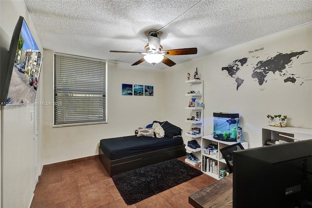 bedroom with ceiling fan and a textured ceiling