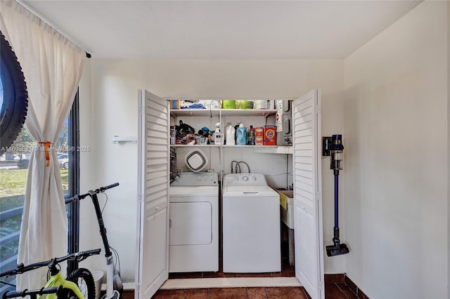 laundry room with dark tile patterned flooring and independent washer and dryer