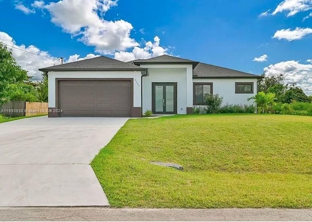 view of front of home with french doors, a front lawn, and a garage