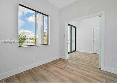 spare room with light hardwood / wood-style flooring