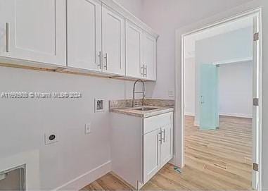 laundry room featuring cabinets, washer hookup, electric dryer hookup, sink, and light hardwood / wood-style floors