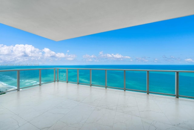 balcony with a water view and a beach view