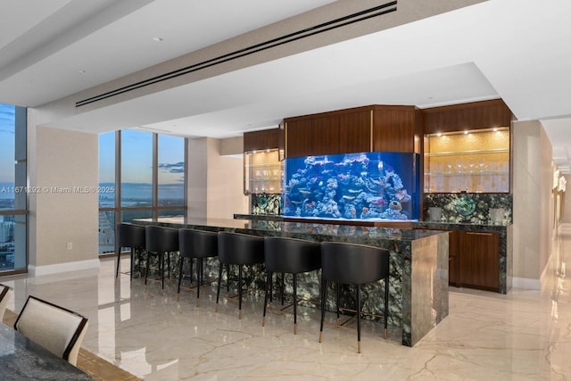 kitchen with a kitchen bar, expansive windows, and a water view