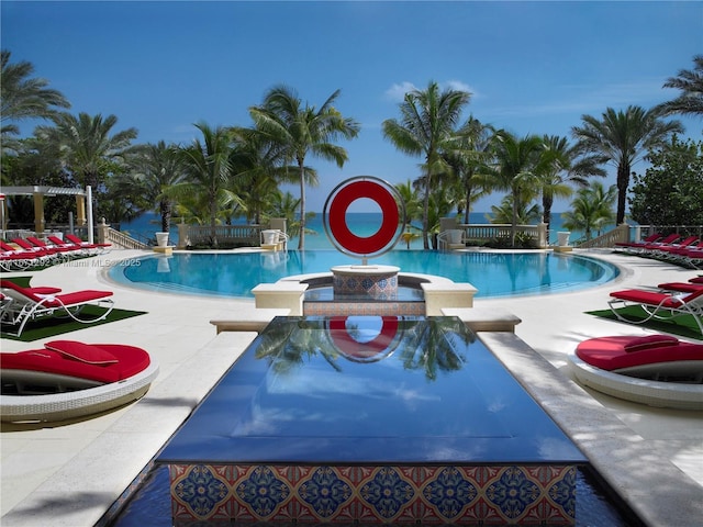 view of swimming pool with a patio area and a water view