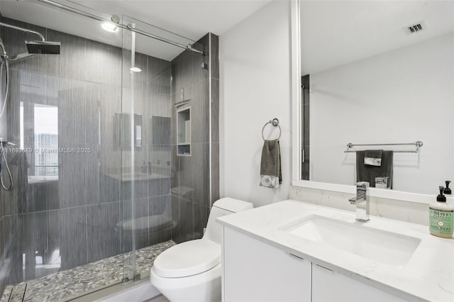 bathroom with an enclosed shower, vanity, and toilet