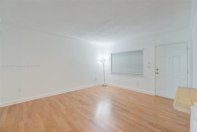 spare room featuring light hardwood / wood-style floors and ornamental molding