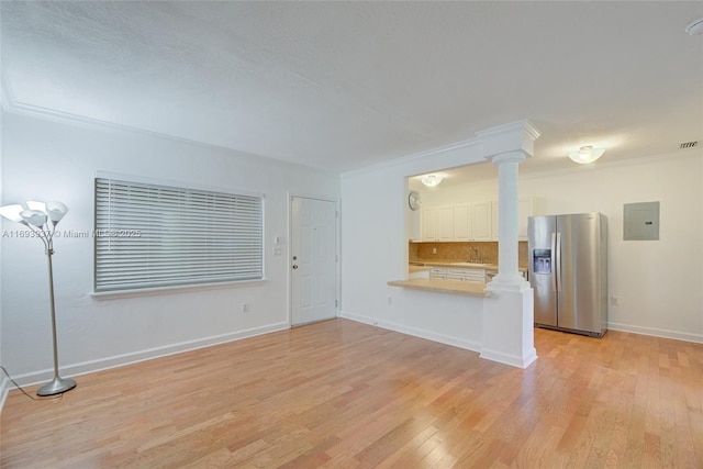 unfurnished living room with light wood-type flooring, electric panel, ornamental molding, and sink