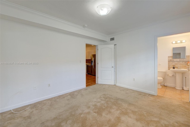 unfurnished bedroom with light colored carpet, crown molding, sink, stainless steel fridge with ice dispenser, and connected bathroom