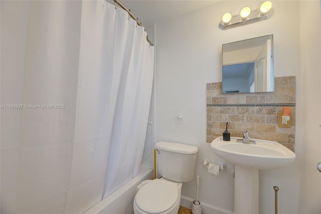 bathroom with decorative backsplash, shower / bath combination with curtain, and toilet