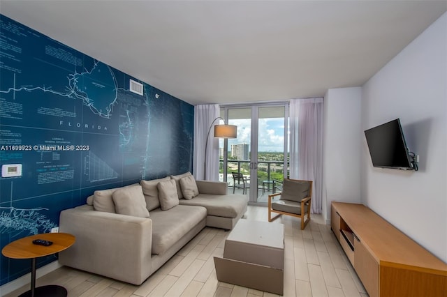 2602 E Hallandale Beach Blvd Unit R1606, Hallandale Beach, FL 33009 - living area with an accent wall, a wall of windows, and light wood finished floors