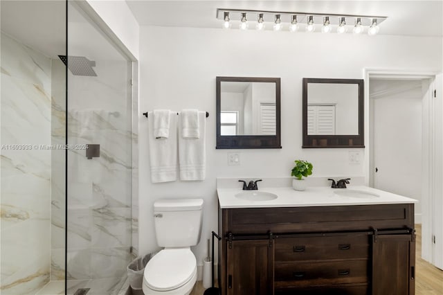 bathroom featuring tiled shower, wood-type flooring, vanity, and toilet