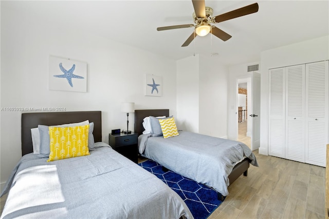 bedroom with hardwood / wood-style floors, ceiling fan, and a closet