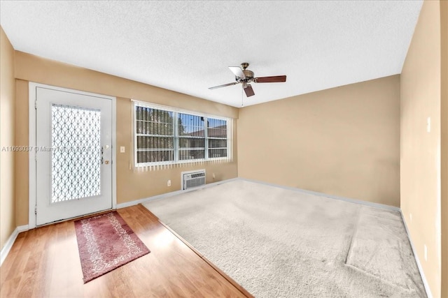 interior space with ceiling fan, hardwood / wood-style floors, and a textured ceiling