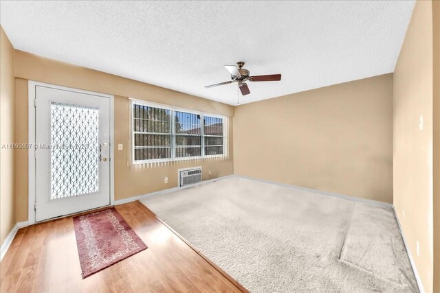 13500 SW 1st St Unit 307U, Pembroke Pines, FL 33027 - spare room with baseboards, ceiling fan, wood finished floors, an AC wall unit, and a textured ceiling