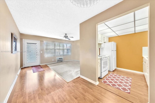 interior space featuring white cabinets, ceiling fan, white appliances, and light hardwood / wood-style flooring