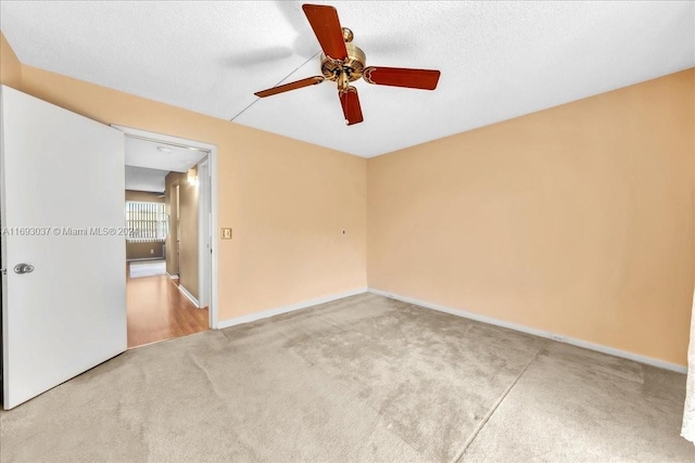 unfurnished room with carpet flooring, ceiling fan, and a textured ceiling