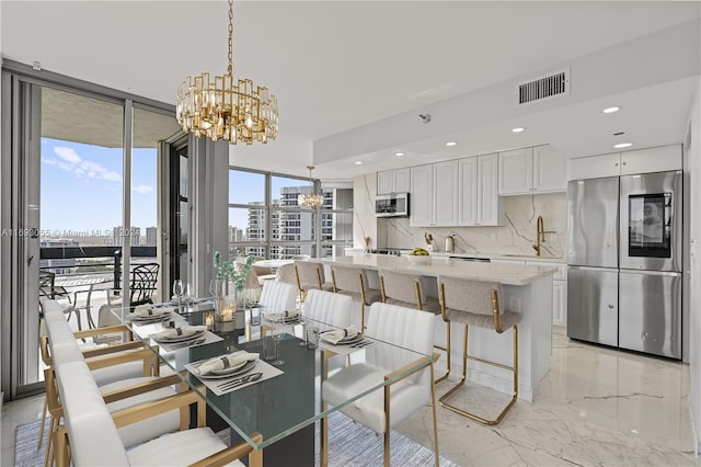 dining room featuring floor to ceiling windows, sink, and an inviting chandelier