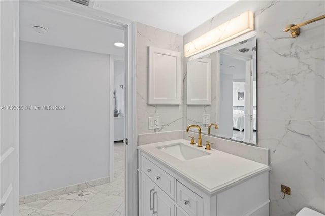 bathroom with vanity and tile walls