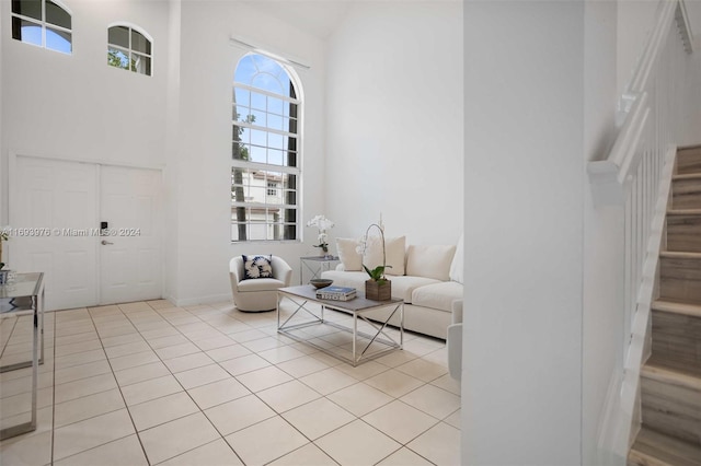 unfurnished living room with light tile patterned flooring and a high ceiling