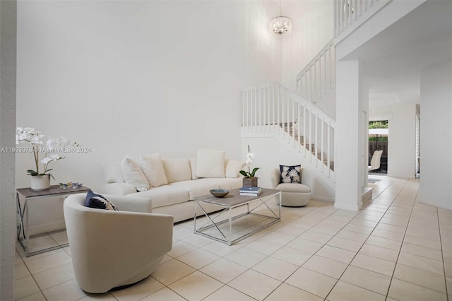 tiled living room with a towering ceiling and a notable chandelier