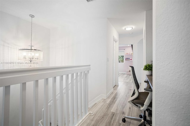 hallway featuring a chandelier and light hardwood / wood-style floors