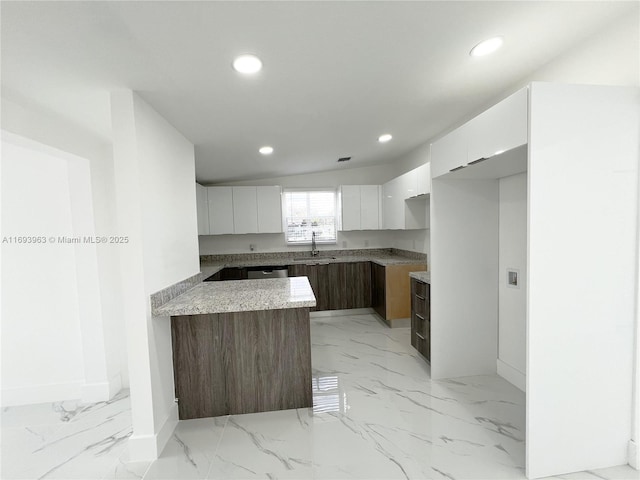 kitchen featuring white cabinetry, stainless steel dishwasher, sink, and dark brown cabinets