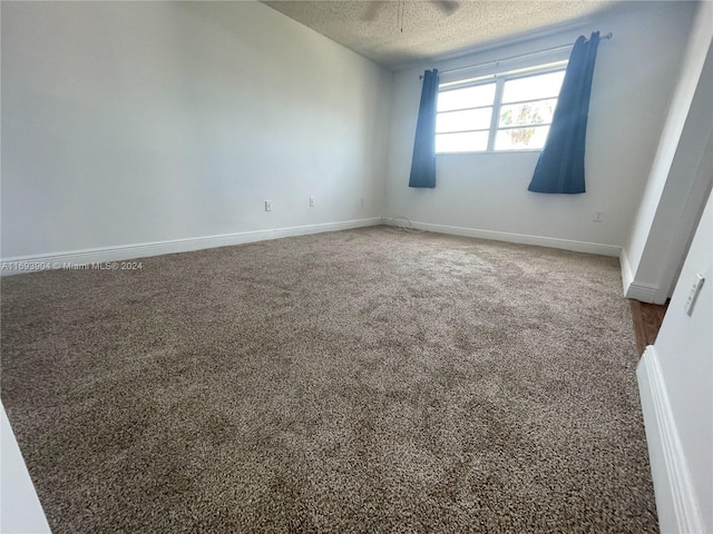 carpeted spare room featuring a textured ceiling