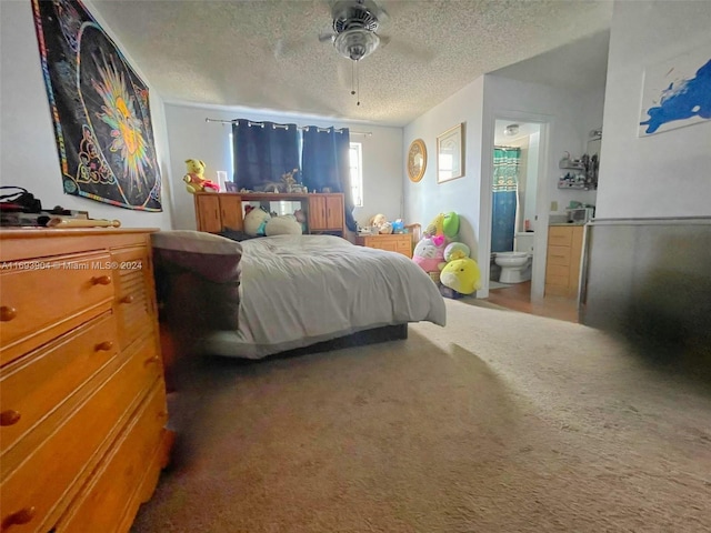 bedroom featuring carpet flooring, a textured ceiling, ensuite bath, and ceiling fan