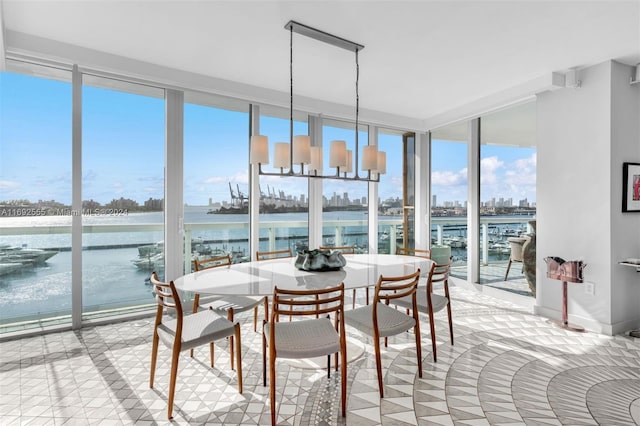 sunroom / solarium featuring a chandelier and a water view