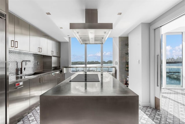 kitchen with black electric stovetop, white cabinetry, a wealth of natural light, and sink