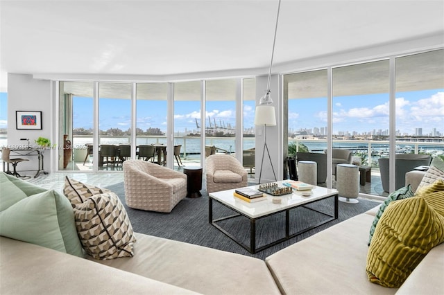 living room featuring expansive windows, a water view, and a wealth of natural light