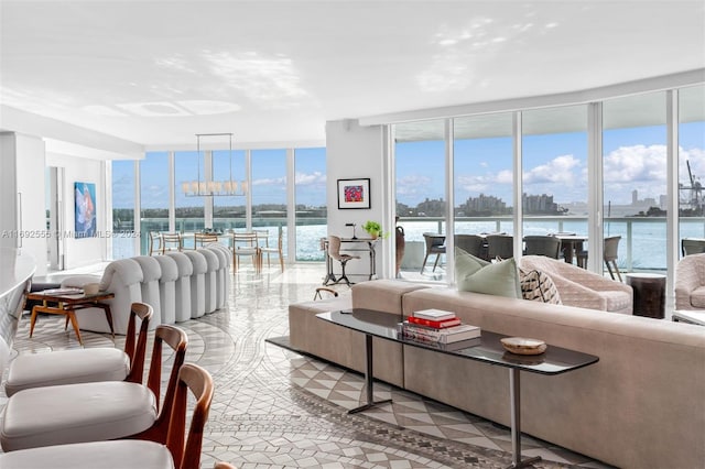 living room featuring plenty of natural light, expansive windows, a water view, and light tile patterned floors